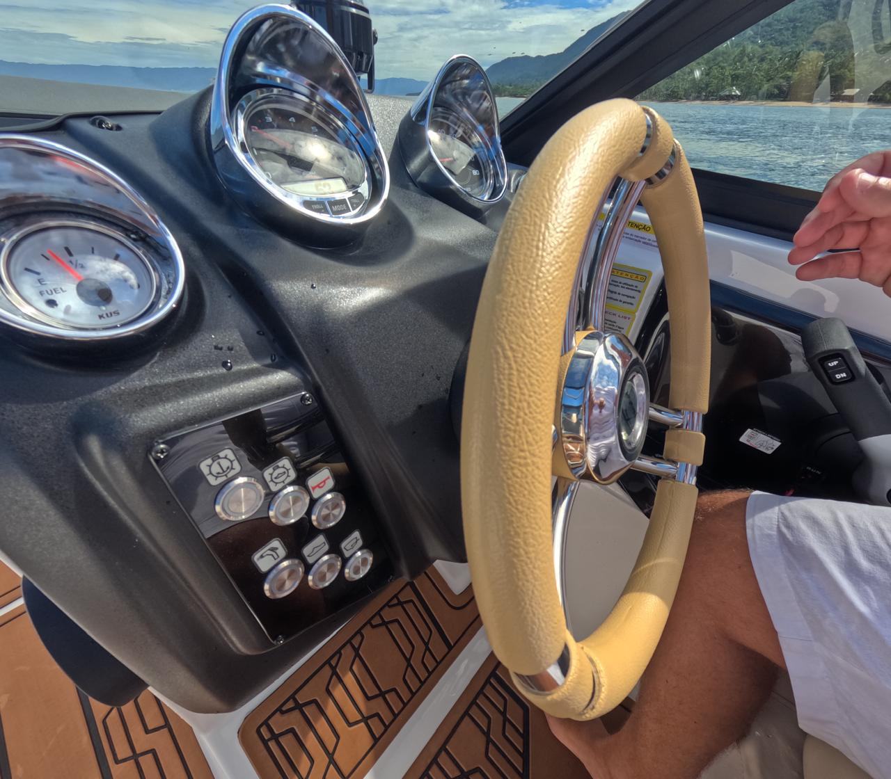 Detalhe do painel com botoes de controle e volante em couro