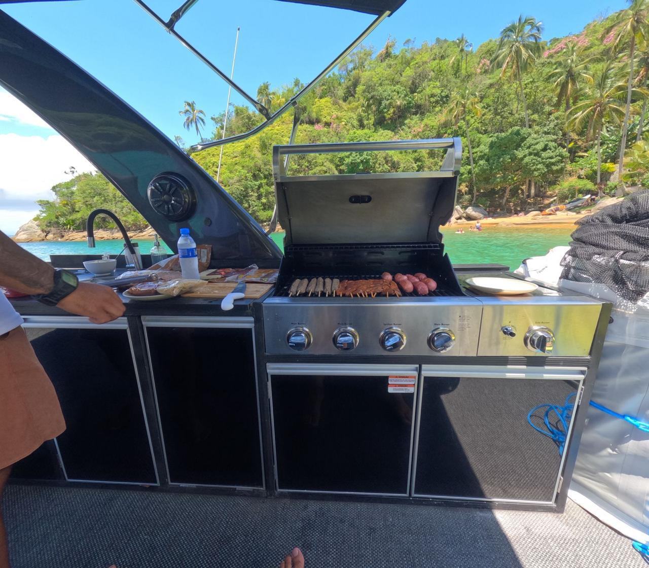 Churrasco a bordo - grelha com carne, linguica e coxinha durante o passeio