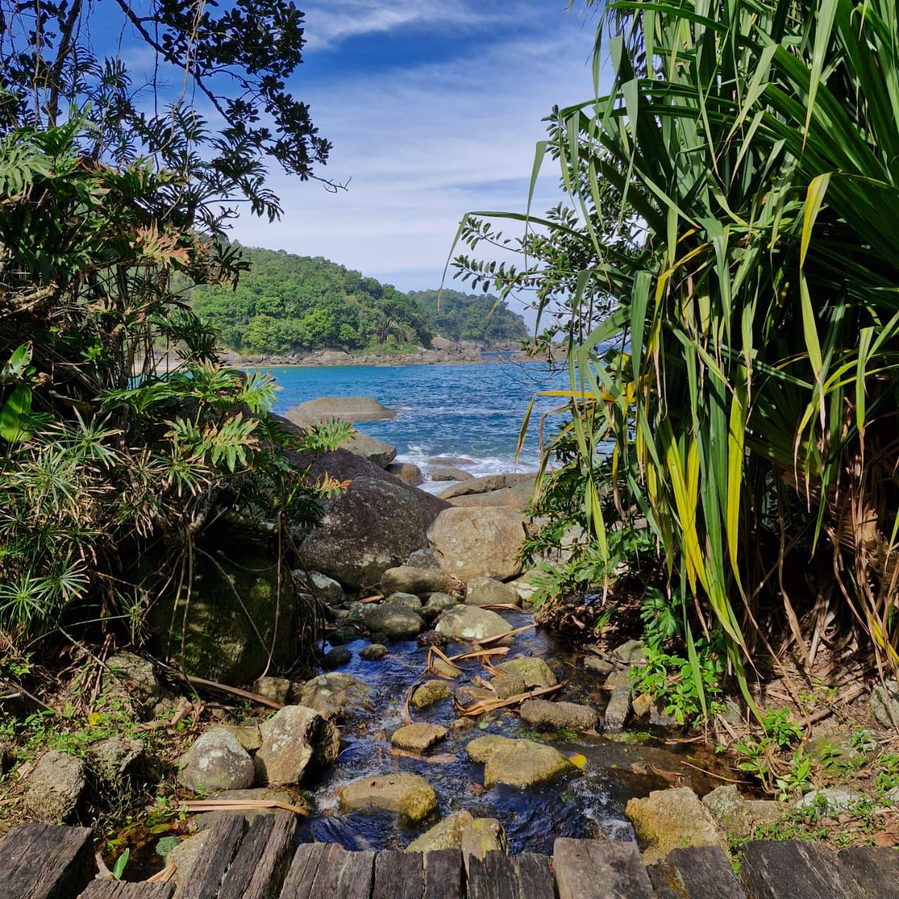 Corrego de agua doce descendo entre pedras ate o mar na Praia de Indaiauba