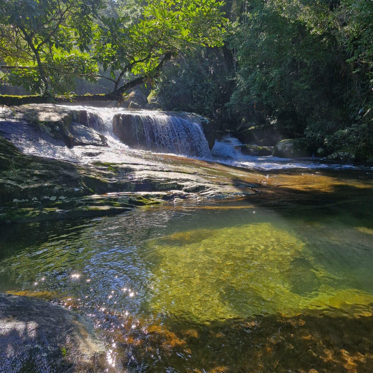 Cachoeira da Lage com queda em cascata sobre laje de pedra e poco na base